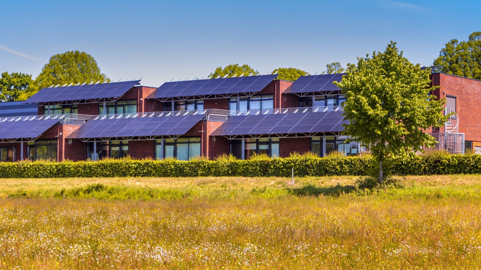 Bedrijfspand met zonnepanelen in een Twents landschap, beheerd door ITK Vastgoedbeheer